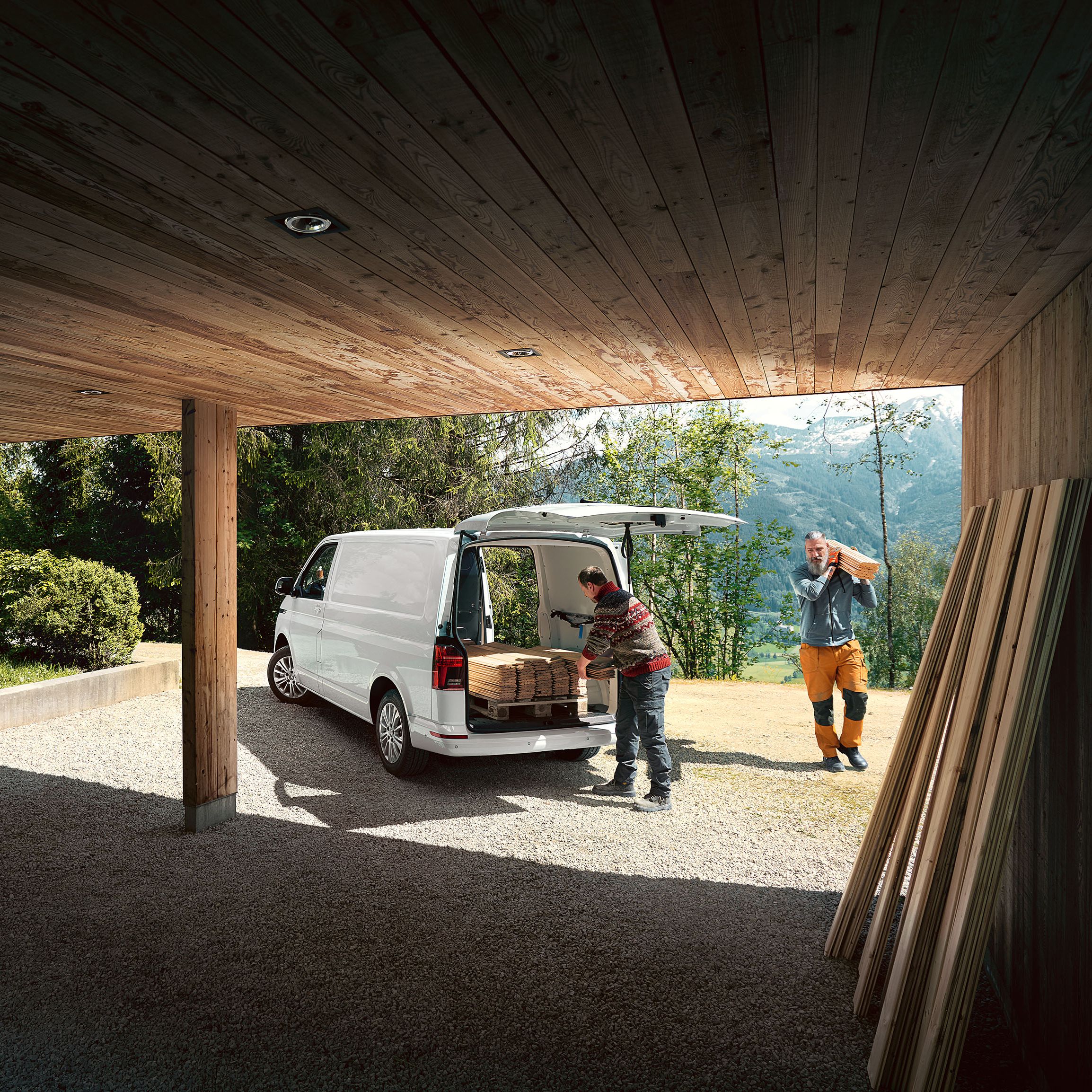 VW Caddy in Grau steht vor einem Gebäude. 