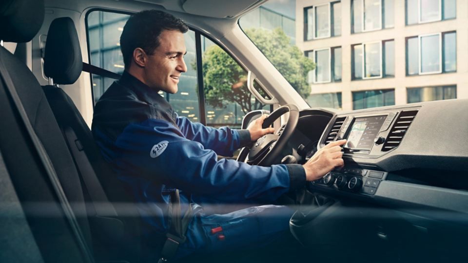 Ein Mann ist zu sehen, der im Inneren eines Autos Car-Net bedient.