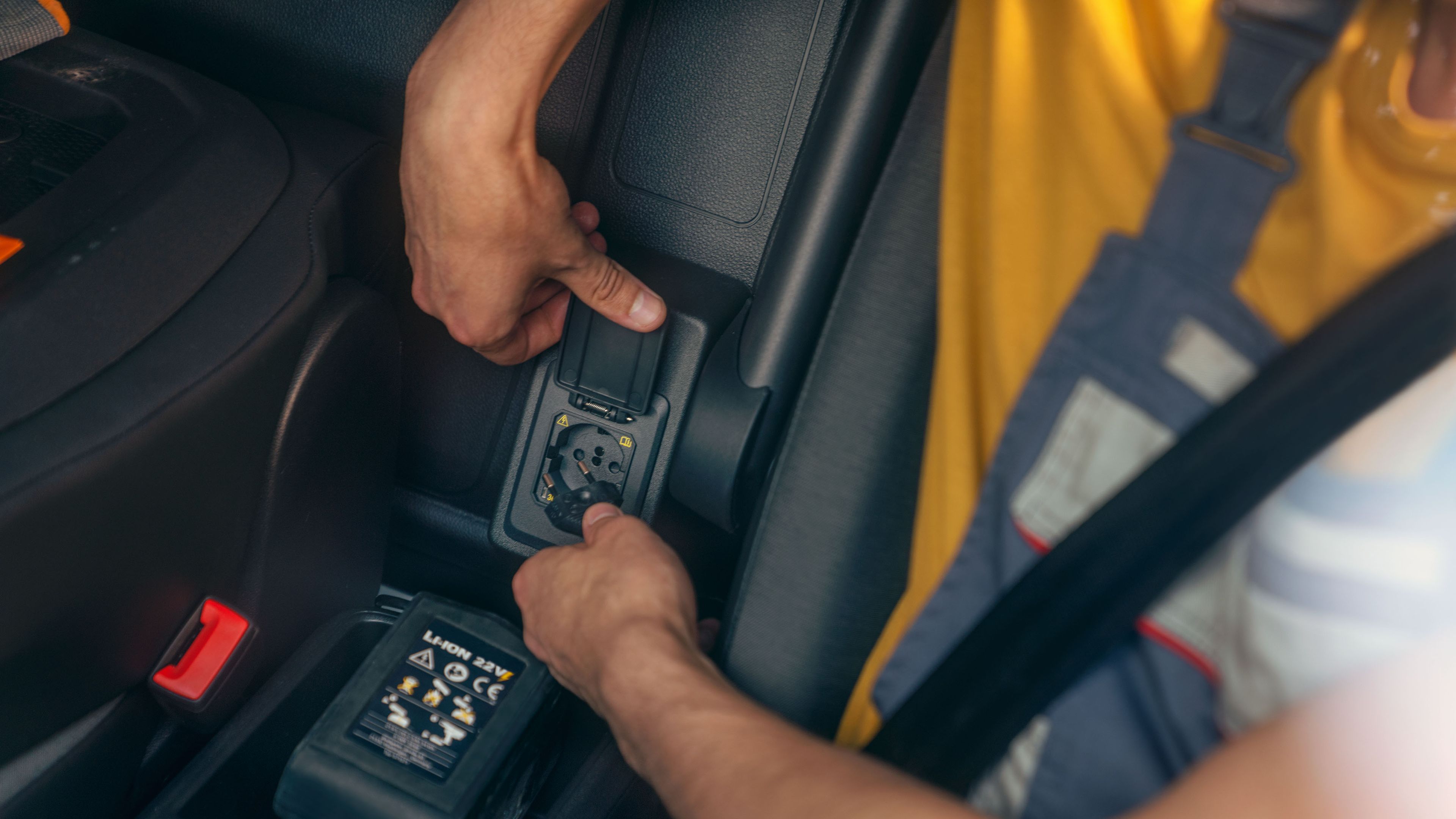 Zu sehen ist die Steckdose unter der Mittelarmlehne in einem VW Caddy Cargo.