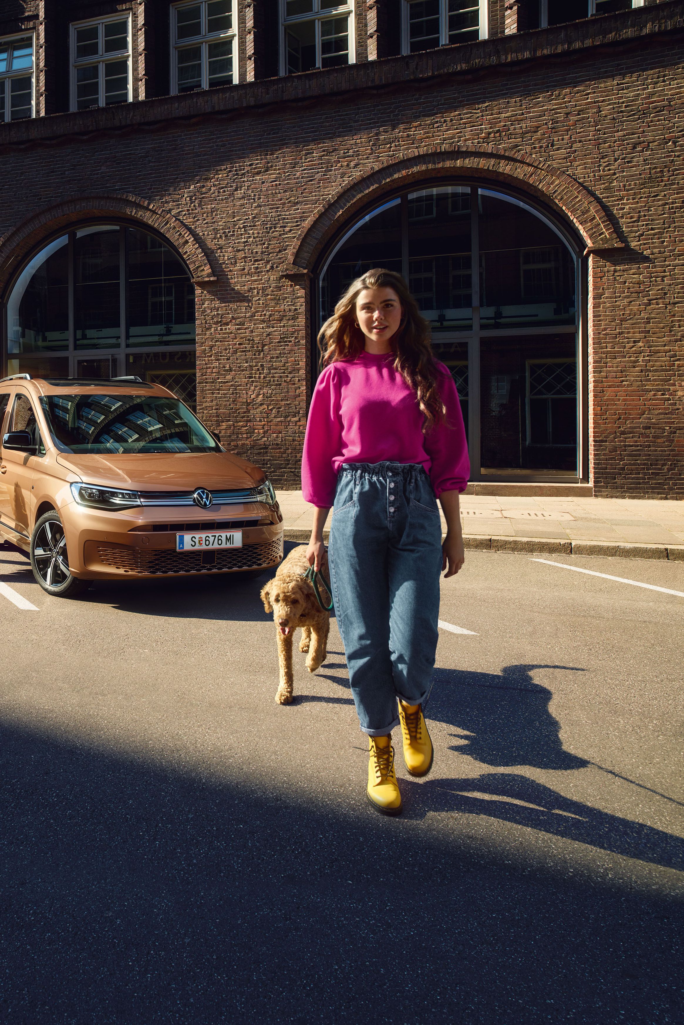 Eine Familie mit ihrem Hund mit einem VW Caddy.