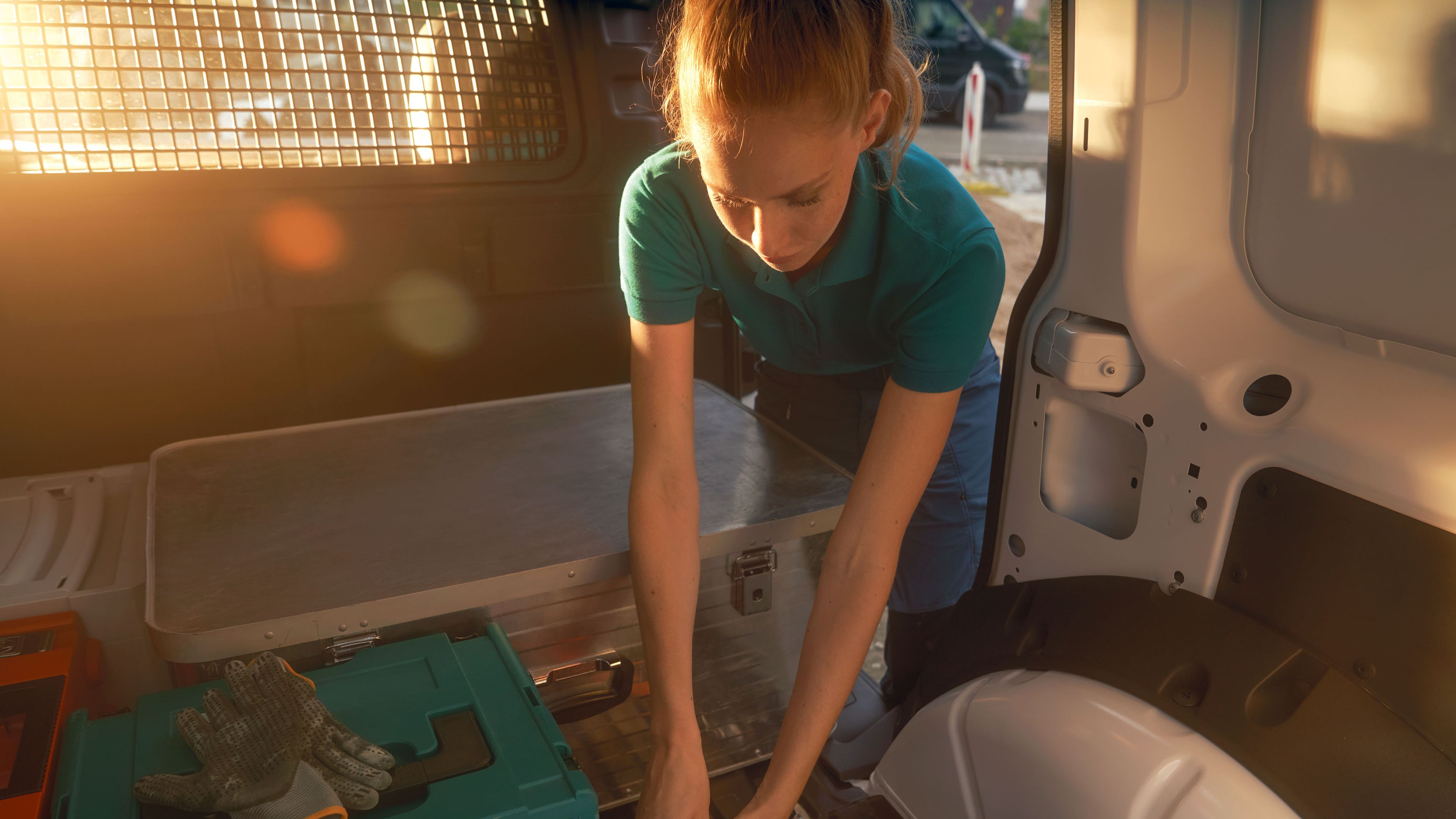 Eine Frau beim Beladen eines weißen VW Caddy Cargo.