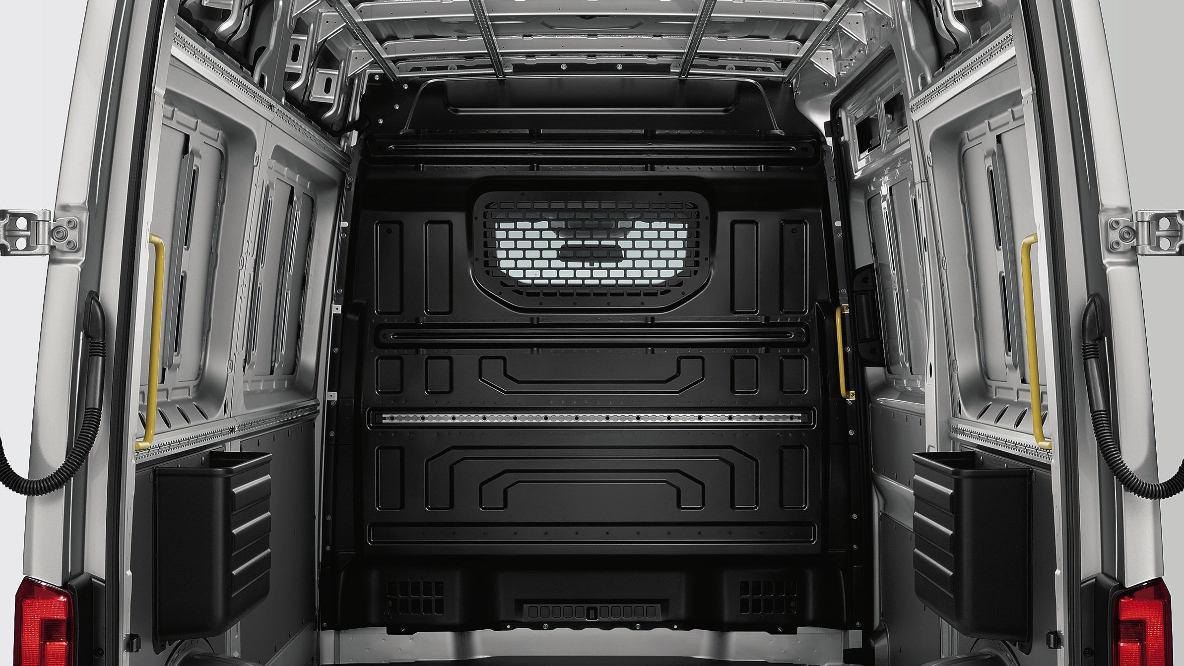 Ein Blick in den Laderaum des Volkswagen Nutzfahrzeuge Crafter Kastenwagen. Darin ist die Trennwand mit Fenster und Schutzgitter zu sehen.