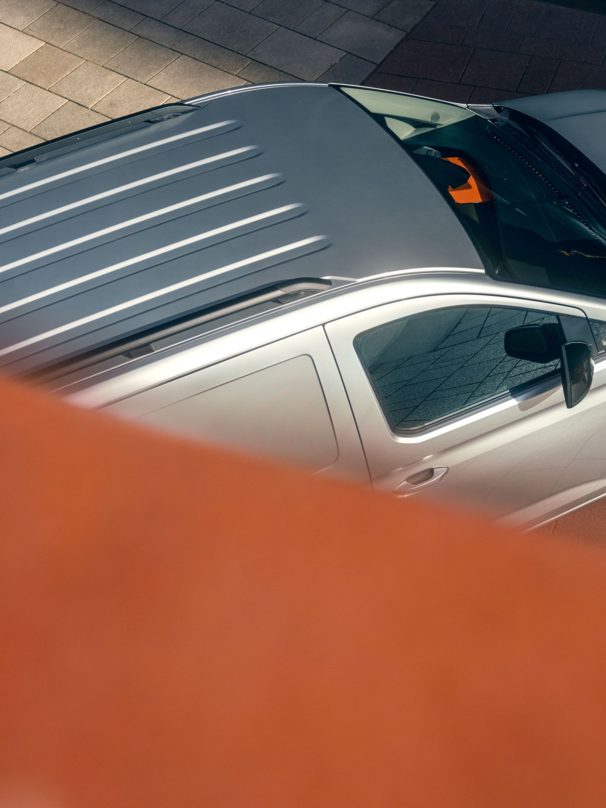 Mann lehnt an einem silbernen Caddy Cargo Maxi.