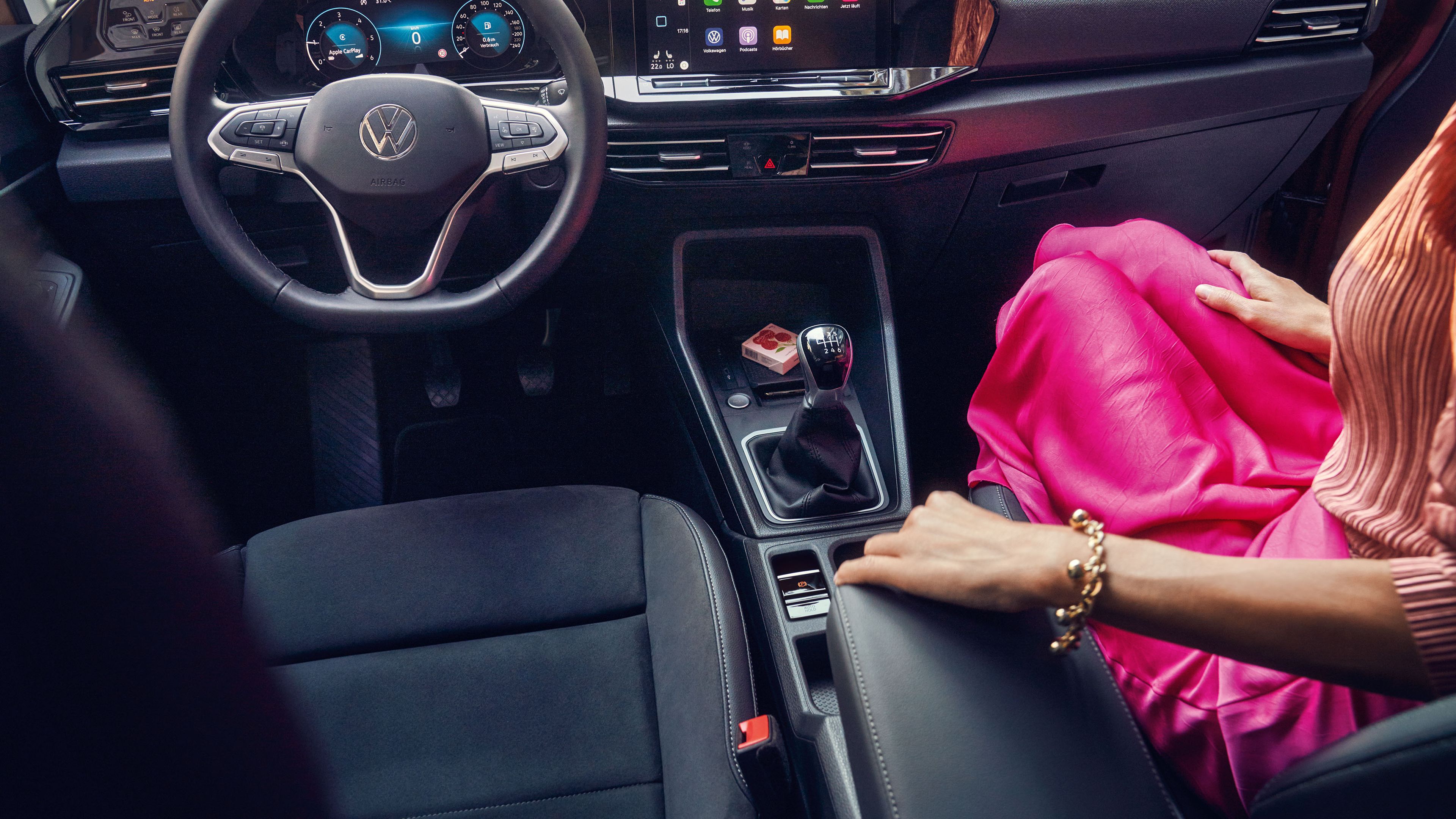 Eine Frau sitzt in einem VW Caddy. Zu sehen ist der Innenraum und die Digitalanzeigen.