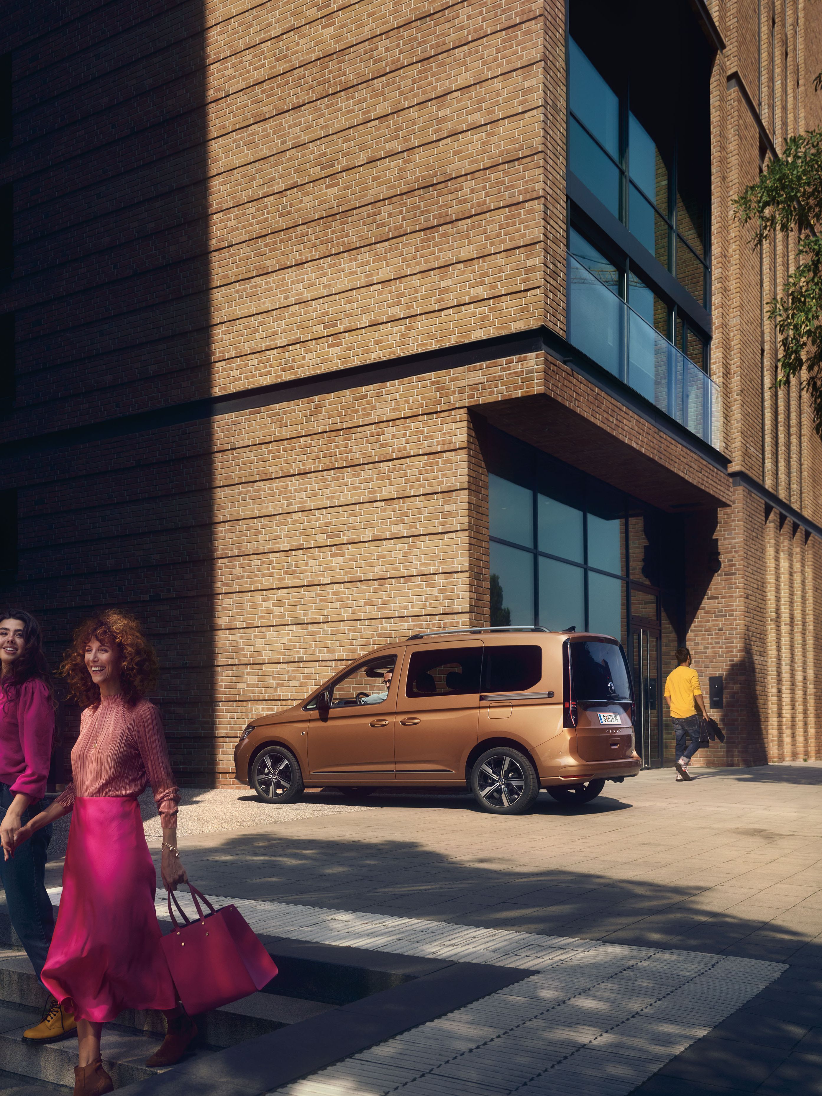 Die Mutter geht mit ihrer Tochter die Stiege hinunter, dahinter ist ein VW Caddy zu sehen.
